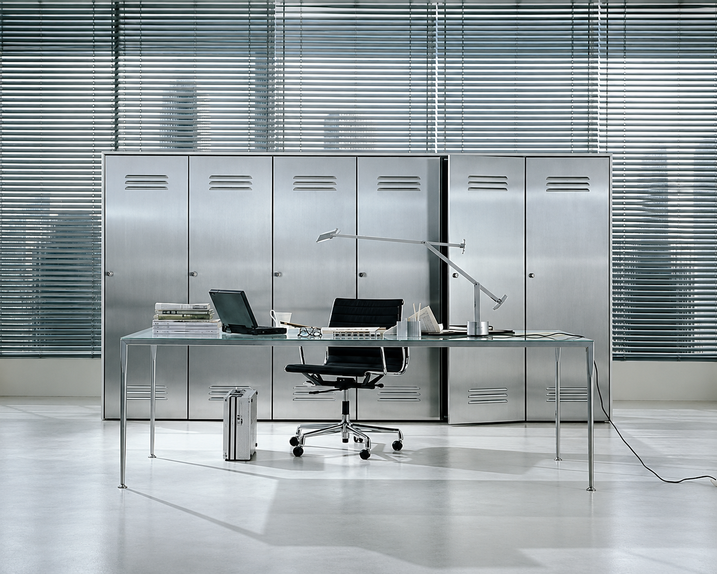 Steel lockers, venetian blinds and a glass desk in a quiet silver office