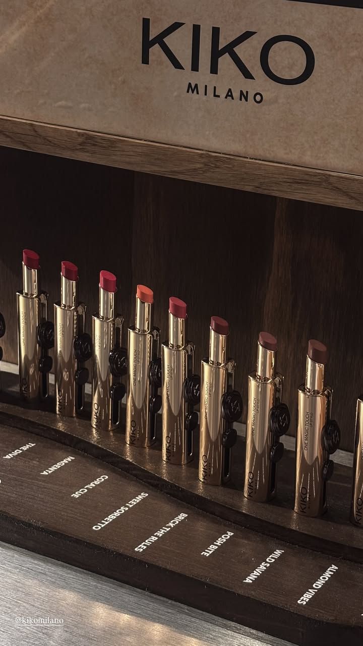 Row of gold lipsticks on a wooden display